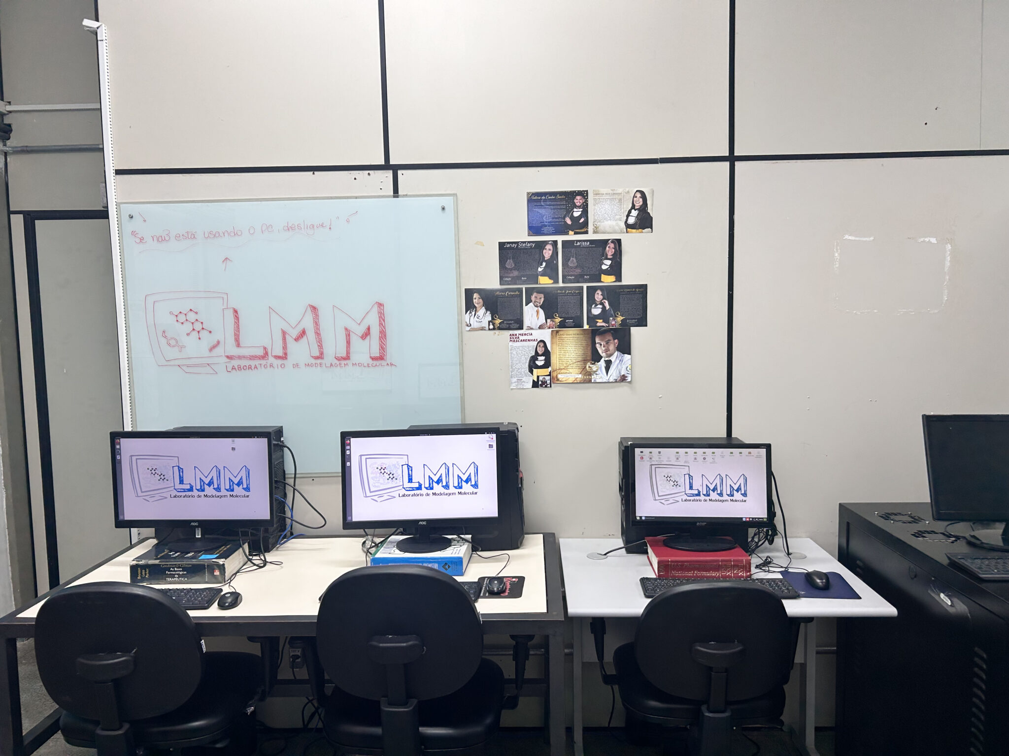 Estações de trabalho do LMM, com o nome do laboratório no quadro ao fundo